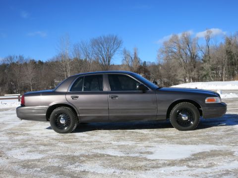 2001 Ford Crown Victoria - A side view of a gray 2001 Ford Crown Victoria is captured on a bright, clear day with snow on the ground.