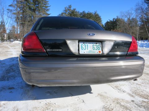 2001 Ford Crown Victoria - The rear of a Ford Crown Victoria Police Interceptor is shown parked in a snowy area under a clear blue sky.