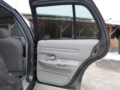 2001 Ford Crown Victoria - The interior of a car is visible, showing the rear door panel and seat.