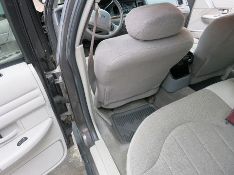 2001 Ford Crown Victoria - The interior of a 2001 Ford Crown Victoria is shown, focusing on the front seats and dashboard area around the driver's area.
