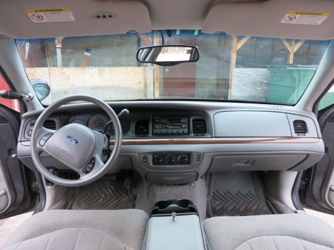 2001 Ford Crown Victoria - The interior of a 2001 Ford Crown Victoria shows a gray dashboard, steering wheel, and seats.