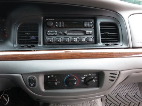 2001 Ford Crown Victoria - Close-up of a car's dashboard, showing the center console with audio controls and HVAC settings.