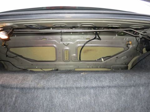 2001 Ford Crown Victoria - The interior of the trunk of a 2001 Ford Crown Victoria, showing the metal structure and wiring.