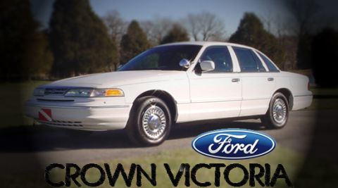 1999 Mercury Grand Marquis - White sedan with a Ford logo and 'CROWN VICTOR' text visible.