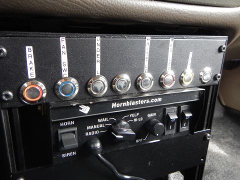 2003 Ford Crown Victoria - Close-up of a Hornblasters.com switch panel showing labeled toggles, a horn/siren switch, and wail/yelp gain controls.
