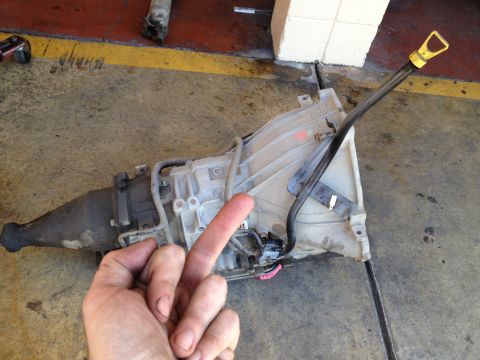 2004 Ford Crown Victoria - A person's hand is in the foreground, obscuring part of a removed automatic transmission.