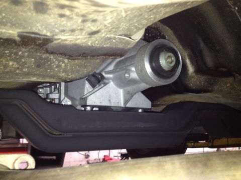 2004 Ford Crown Victoria - Close-up view of the underside of a vehicle, focusing on the transmission and exhaust system components.