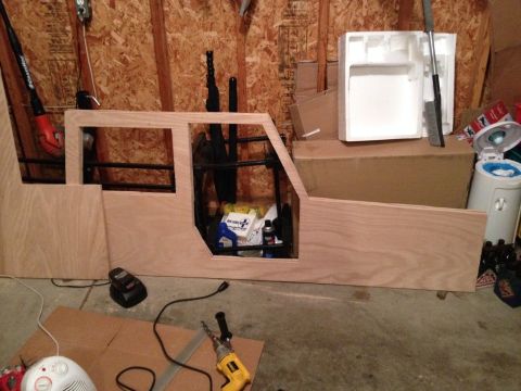 2005 Jeep Wrangler - A partially constructed wooden shell resembling a vehicle's interior is shown in a garage setting.
