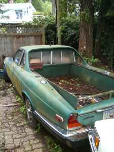 1972 Ford Ranchero - This green pickup truck appears to be in a state of disrepair, with a weathered bed and visible damage.