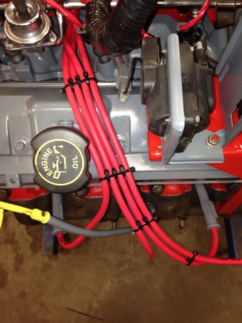 1993 Ford Bronco - Close-up view of engine components, including red spark plug wires and an ignition coil.