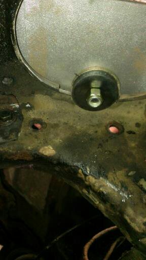 1996 Ford Bronco - Detail of a vehicle's frame, showing a bolt securing a rubber mount to a metal component.