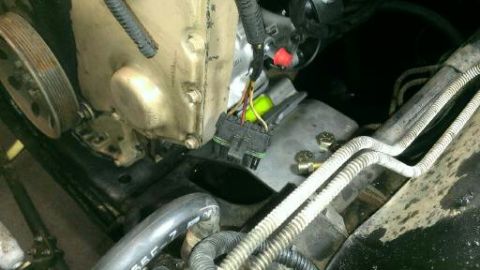 1996 Ford Bronco - Close-up view of an engine component with a prominent electrical connector and a pulley visible.