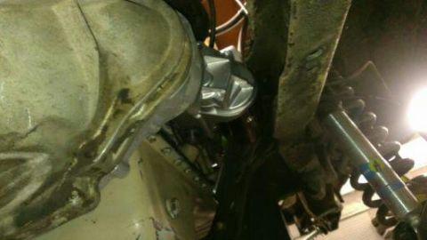1996 Ford Bronco - Close-up of a vehicle's undercarriage, showing mechanical components and suspension parts.