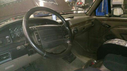 Interior shot of a vehicle, showing the steering wheel, dashboard, and passenger seat