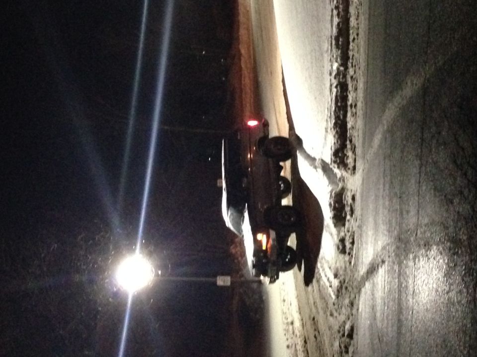 1995 Ford Bronco parked on a snowy road at night