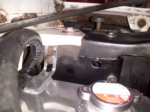 1976 Ford Ranchero - Close-up view of a vehicle's radiator cap and hoses, showing part numbers and warning labels.