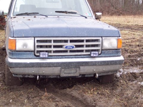 1987 Ford Bronco - This 1987 Ford Bronco is stuck in the mud, showing its front grille and headlights.