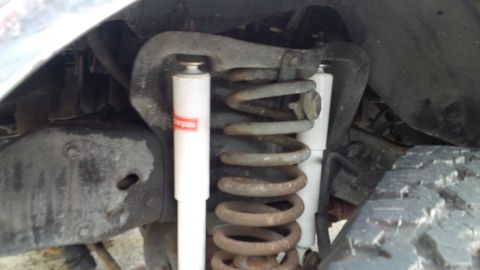 1992 Ford Bronco - The image shows the front suspension system of a vehicle, including a coil spring and shock absorber.
