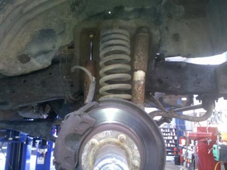 1982 Ford Bronco - Close-up view of the front suspension system on a 1982 Ford Bronco, highlighting the coil spring and shock absorber.