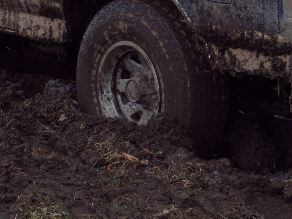tire of a vehicle sunk deep in mud