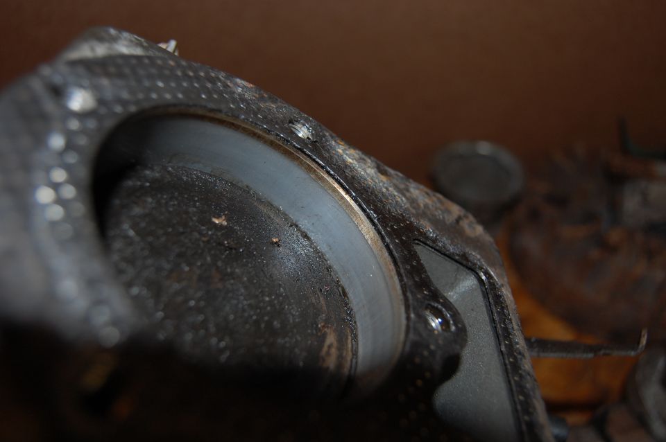 Engine part with a grey ring and textured black casing, close-up