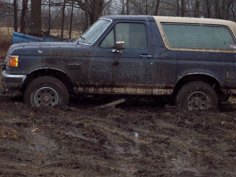 1987 Ford Bronco - This 1987 Ford Bronco is deeply stuck in mud, with its front wheels almost completely submerged.
