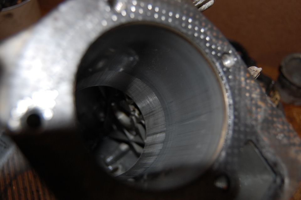 Close-up view inside an exhaust pipe, showing wear marks and some internal structure