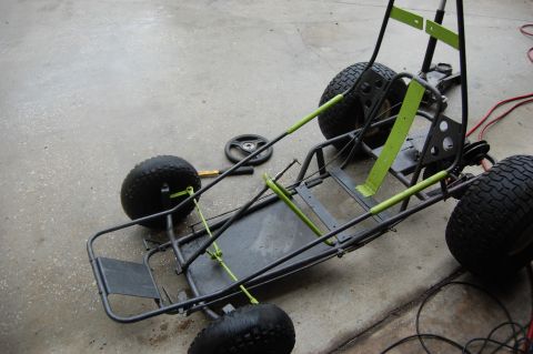 2006 Honda RANCHER - A go-kart frame is shown on a concrete surface, with its steering wheel and some tools placed nearby.