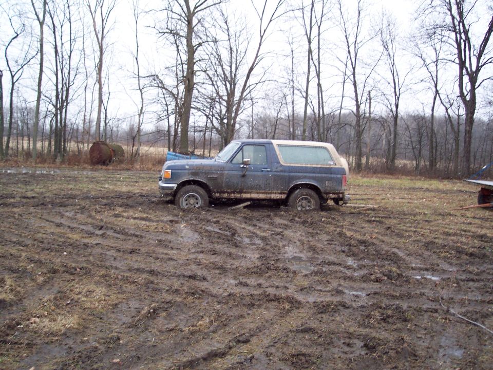 1987 Ford Bronco stuck in mud, side view