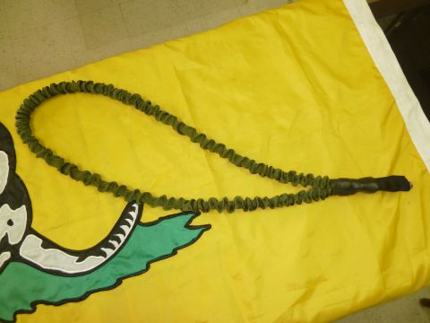 1992 Ford Mustang - A green bungee cord with a black handle rests on a yellow flag a snake emblem.