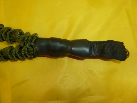 1992 Ford Mustang - Close-up of a green bungee cord with a black grip and strap.