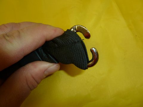 1992 Ford Mustang - A close-up shows a hand gripping a strap with two metal hooks, likely for securing cargo.