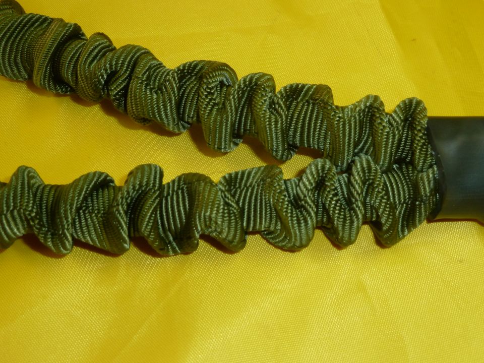 Close-up of two green elastic cords with ruffled texture against a yellow background