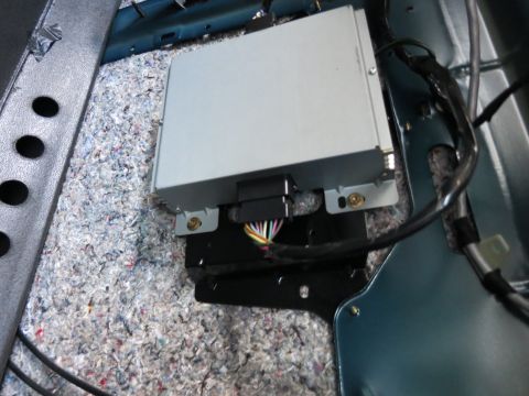 1991 Ford LTD Crown Victoria - Car amplifier module with wiring harness visible, mounted beneath carpeting.