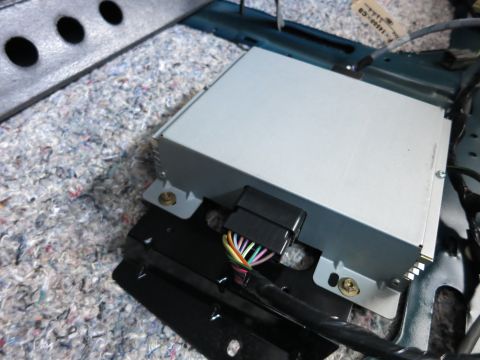 1991 Ford LTD Crown Victoria - Close-up of a car's audio amplifier unit and its wiring harness, installed within the vehicle's cabin.