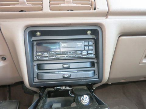 1991 Ford LTD Crown Victoria - Close-up of a car's center console, showing the radio and storage compartments.