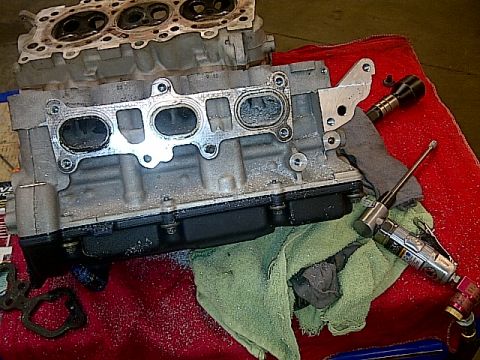 1995 Ford Probe - Disassembled engine components are laid out on a red cloth, with tools and metal shavings scattered around.