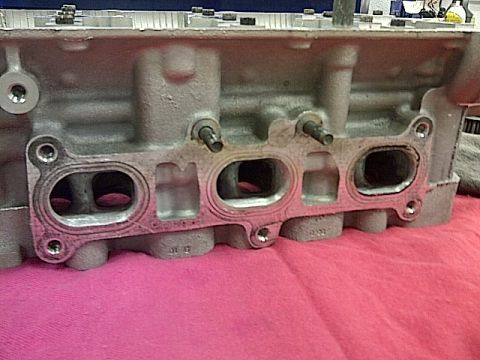 1995 Ford Probe - Close-up of an engine cylinder head, showing the intake ports and gasket surface.