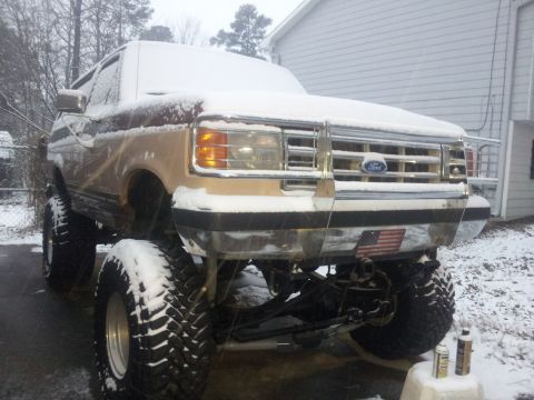 1988 Ford Bronco - This lifted Ford Bronco is parked outside in the snow.