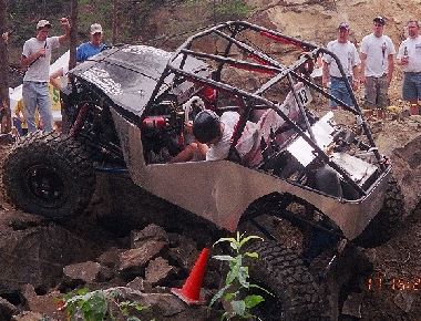 1994 Ford Bronco - Custom off-road buggy navigates a rocky obstacle course with spectators observing.