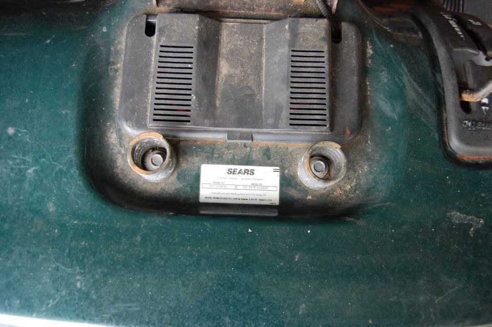 Green lawn mower deck with a Sears identification label and two bolt holes