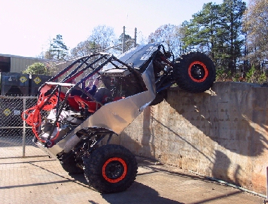 1994 Ford Bronco - This custom buggy is attempting to climb a concrete wall, showing its extreme off-road capabilities.