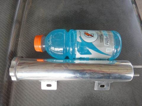 1995 Ford Taurus - A coolant overflow tank is shown with a bottle of Gatorade placed on it for scale.