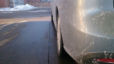 2012 Mazda Mazda 5 - Side view of a silver vehicle's rear quarter panel and wheel, showing road salt residue.