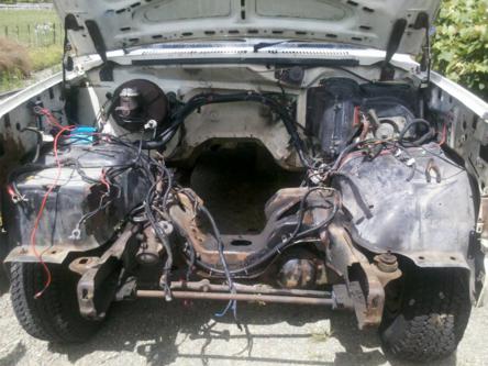 1982 Ford Bronco - Engine bay of a 1982 Ford Bronco, with the engine removed and wiring exposed.
