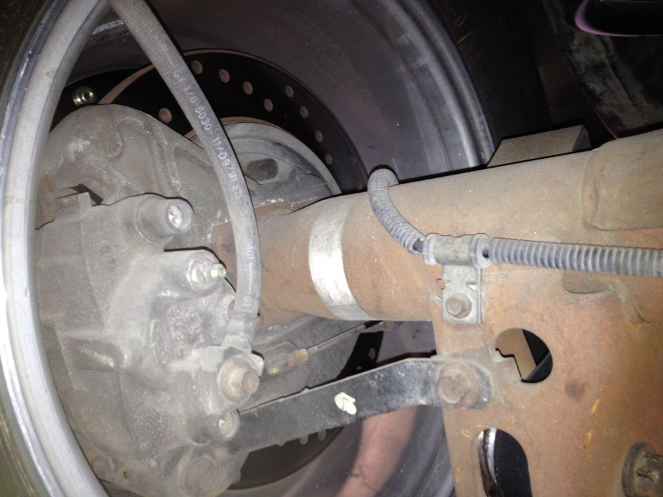 Rear axle and brake assembly with visible text on brake hose