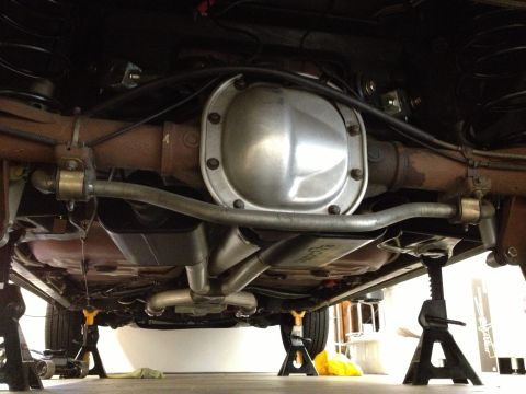 1992 Ford Crown Victoria - Underside view of a car's rear axle and exhaust system on jack stands.