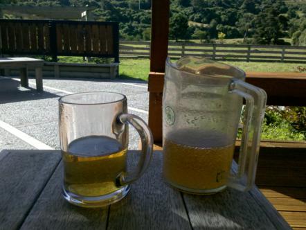 1982 Ford Bronco - Two mugs of beer sit on a table outdoors, with a scenic view behind them.