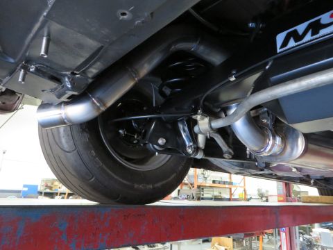 1992 Ford Crown Victoria - Close-up view of the rear suspension and custom exhaust system of a vehicle.