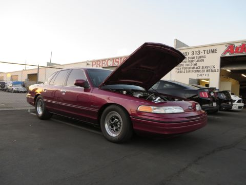 1992 Ford Crown Victoria - Maroon 1992 Ford Crown Victoria with hood open, parked outside a performance shop.
